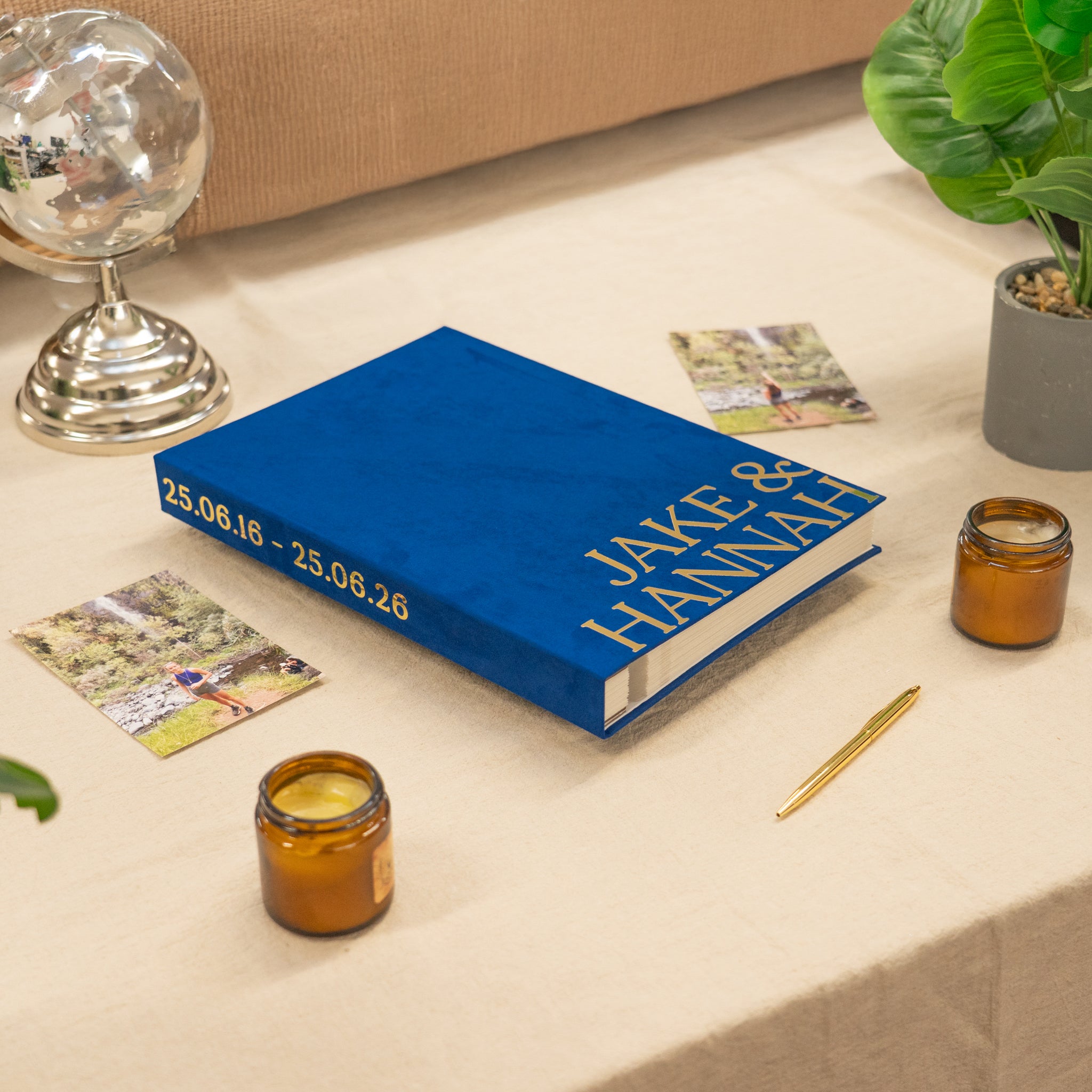 Blue book with personalized text on a table with candles and cards