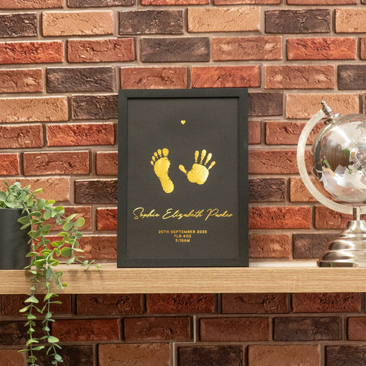 Framed artwork with footprints on a wooden shelf against a brick wall.