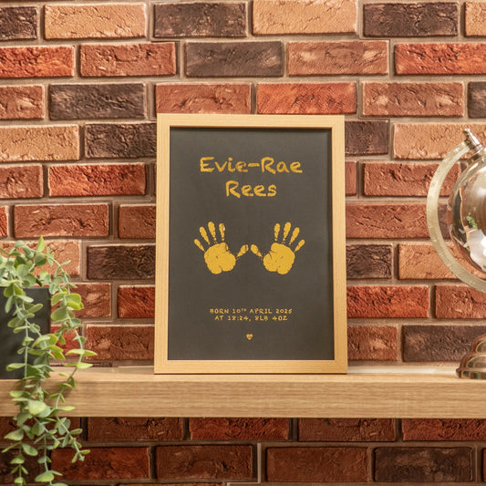 Framed artwork with handprints on a brick wall background