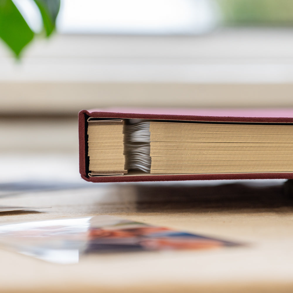 Close-up of a red-bound book with yellowed pages on a blurred background