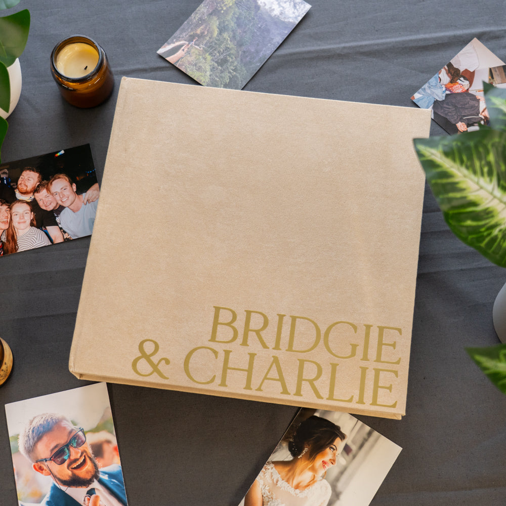 Album with 'Bridgie & Charlie' on a table with photos around