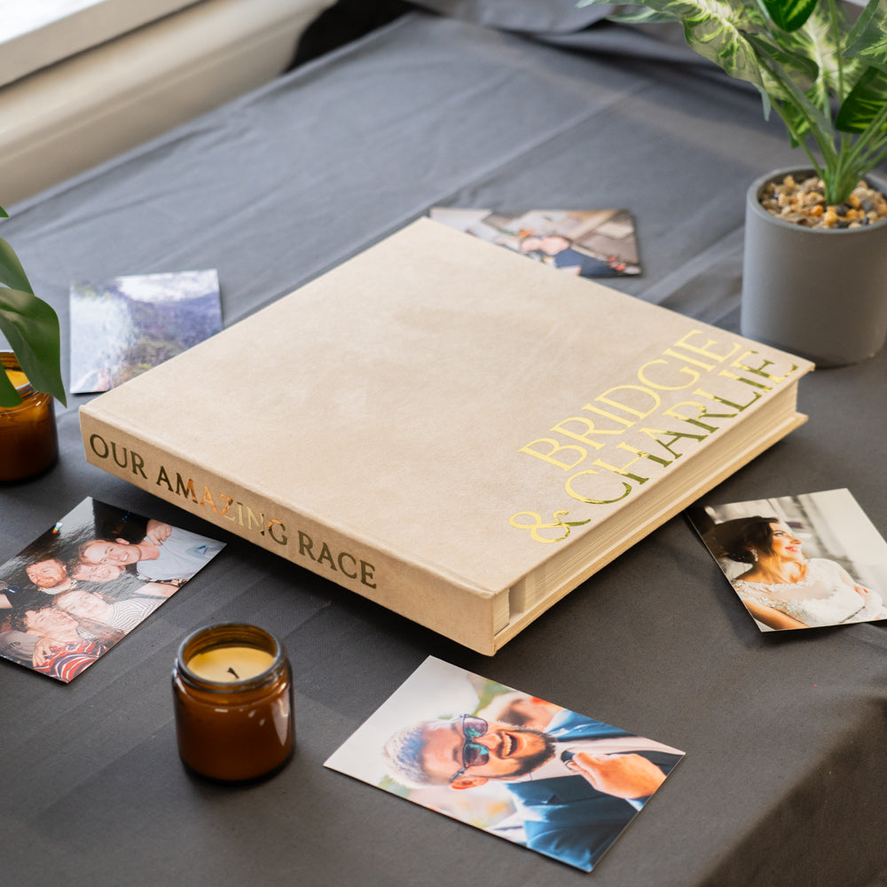 Personalized photo album on a table with photos and a candle