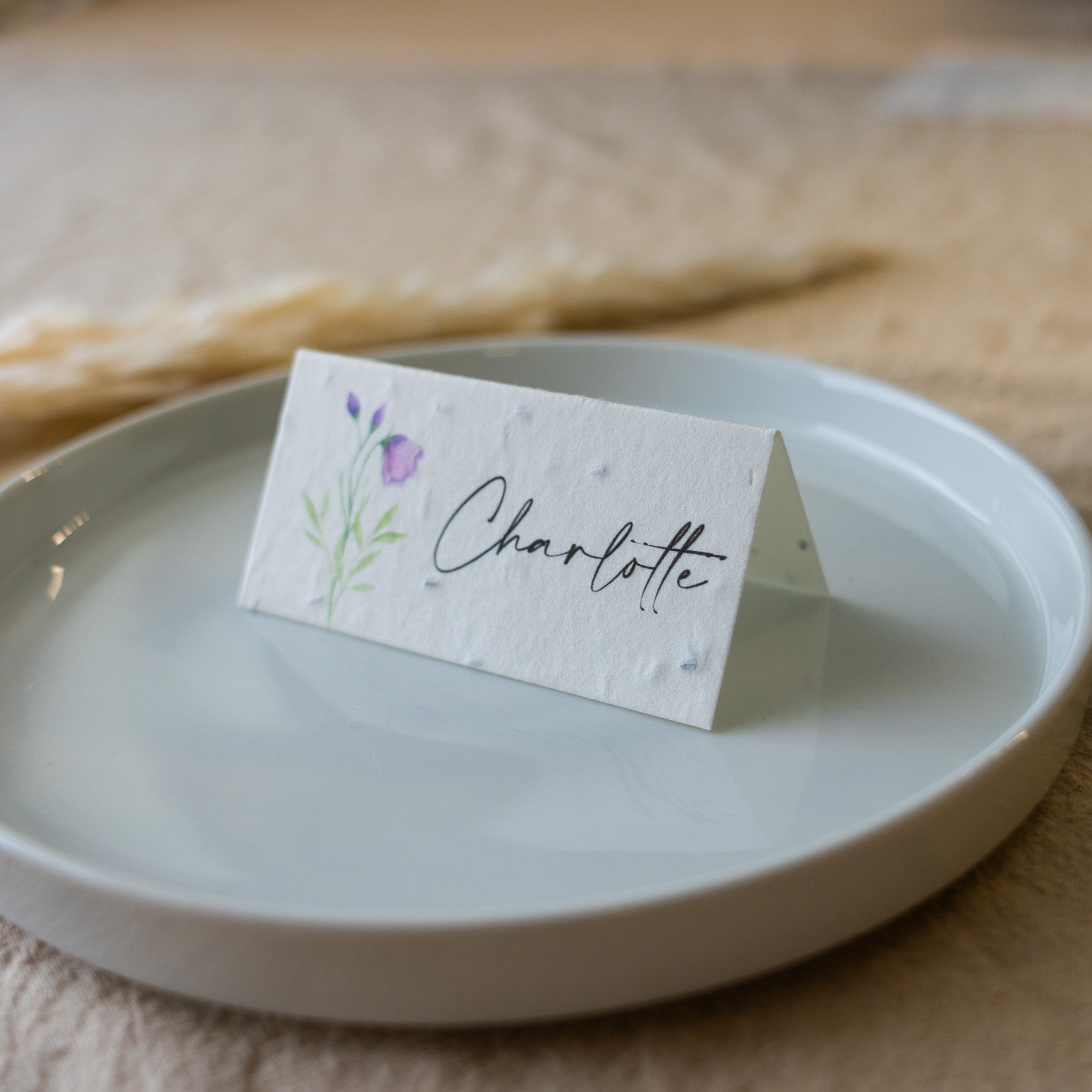 Place card with 'Charlotte' on a white plate with a floral design