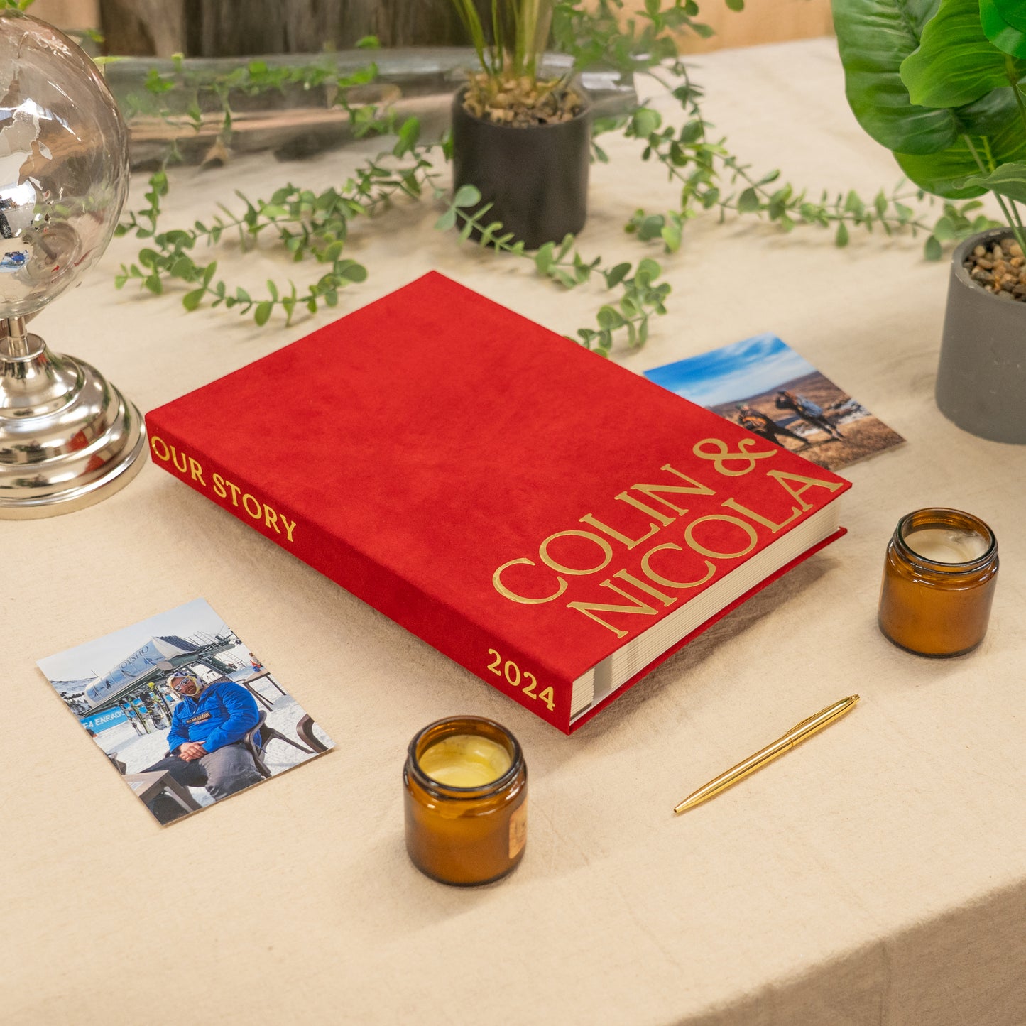 Red book titled 'Our Story Colin & Nicola 2024' on a table with photos and candles.