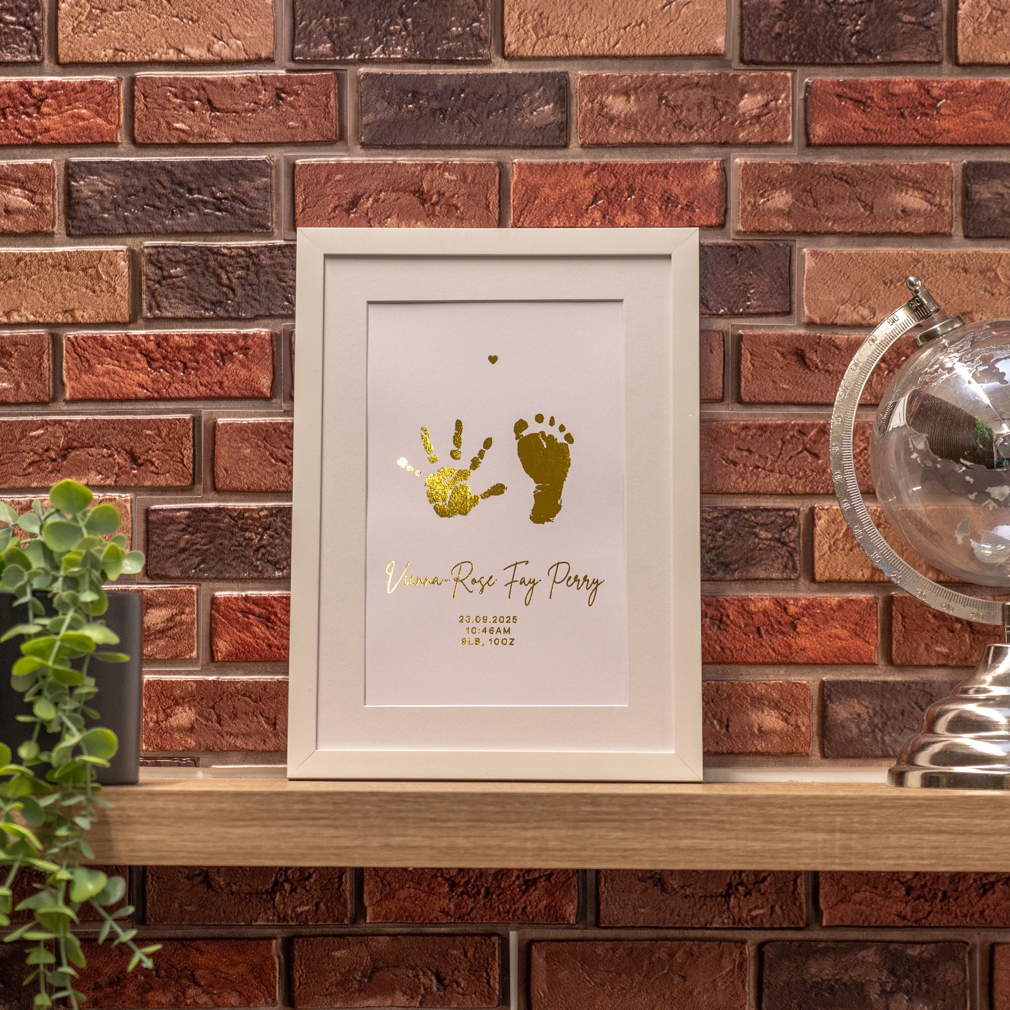 Framed print with hand and footprints on a brick wall background
