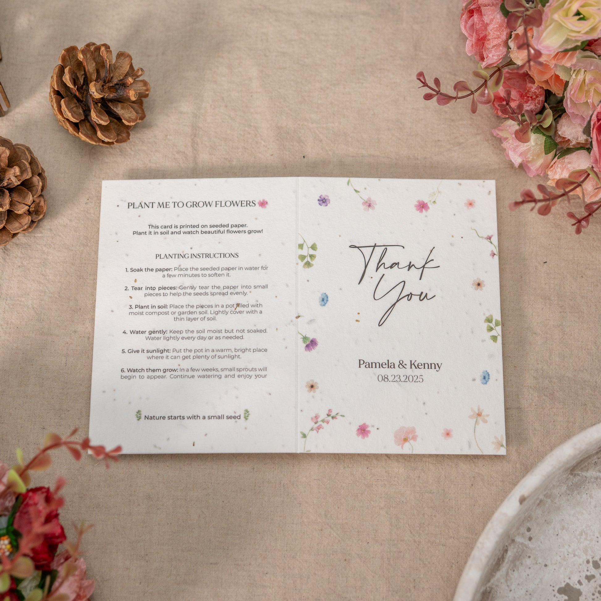 Floral seed paper with planting instructions and 'Thank You' message on a textured surface with flowers and pinecones.