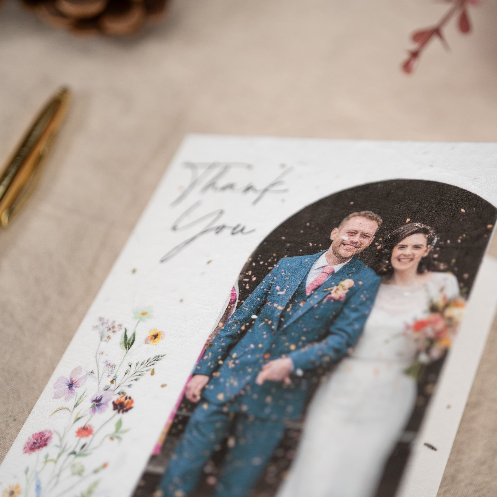 Wedding card with a couple's photo and 'Thank You' text on a textured surface.