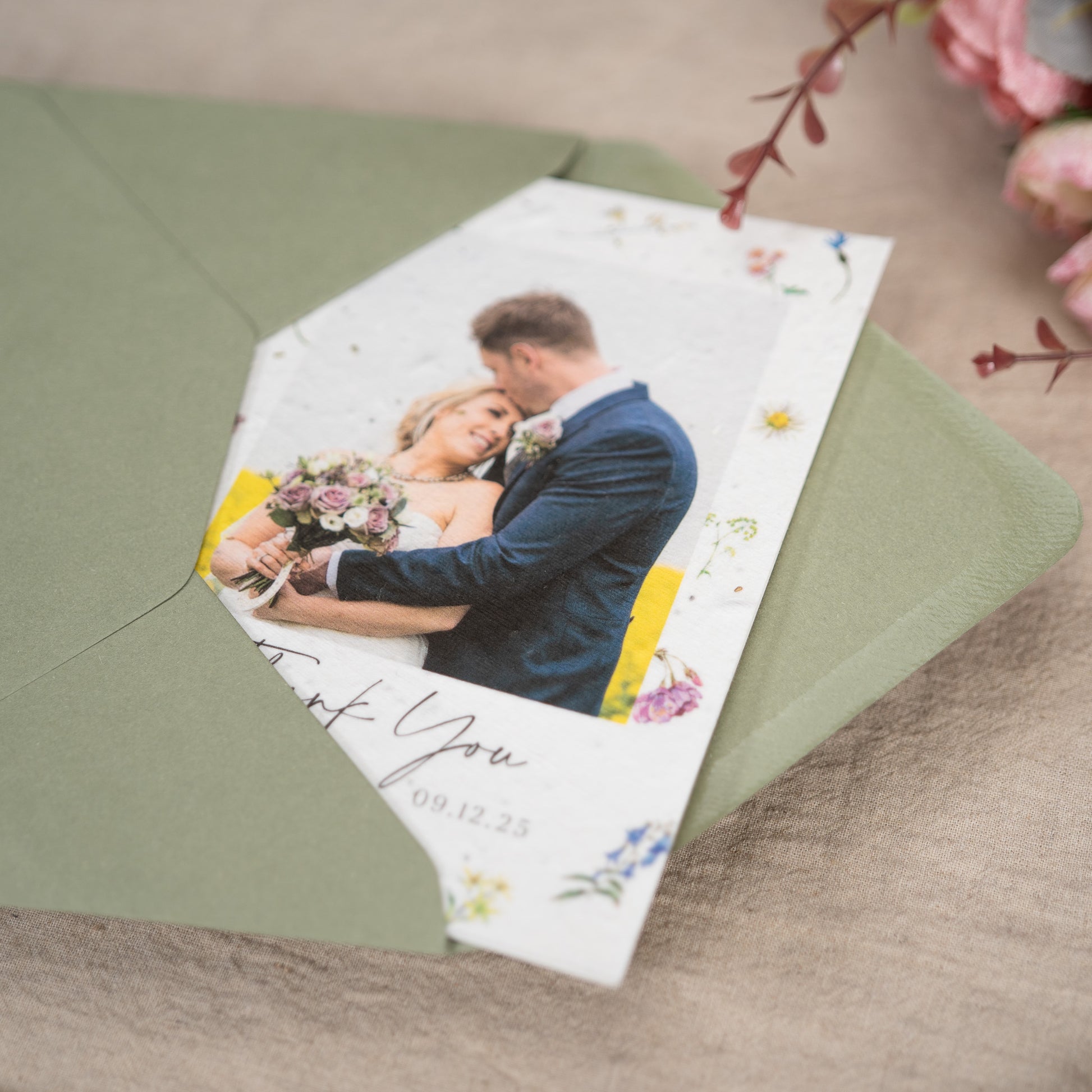A close up shot of a floral wedding card inside a moss green envelope