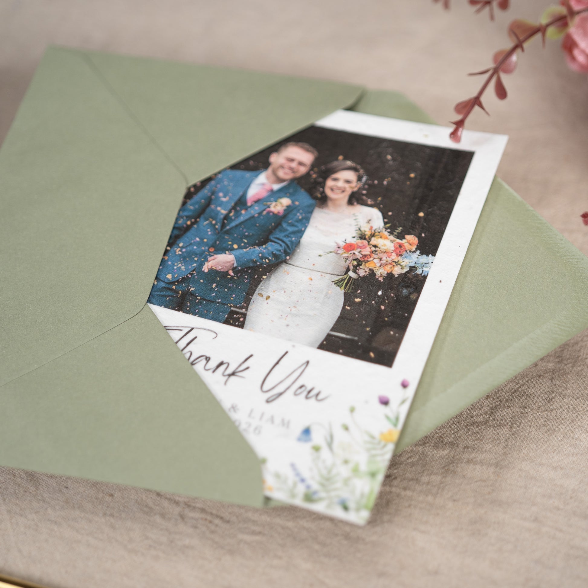 Wedding thank you card with a couple's photo on a green envelope.