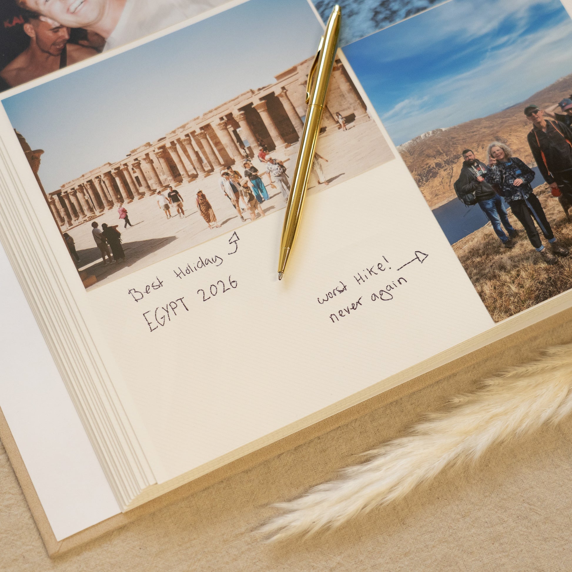 Open photo album with travel photos and handwritten notes on a sandy surface