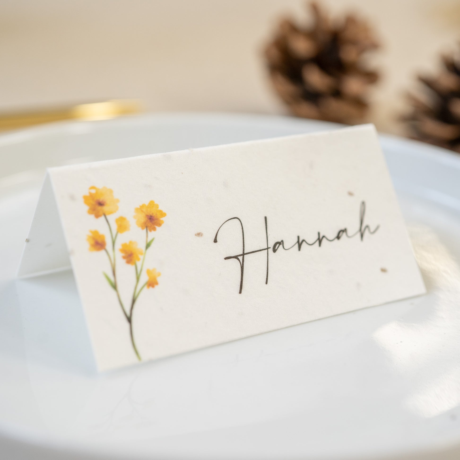 Place card with floral design and 'Hannah' text on a white surface