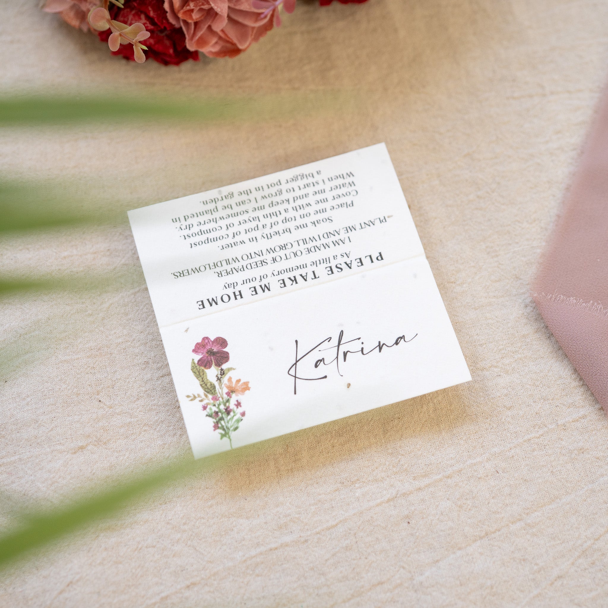 Note with 'Please Take Me Home Katrina' text on a textured surface with flowers in the corner.
