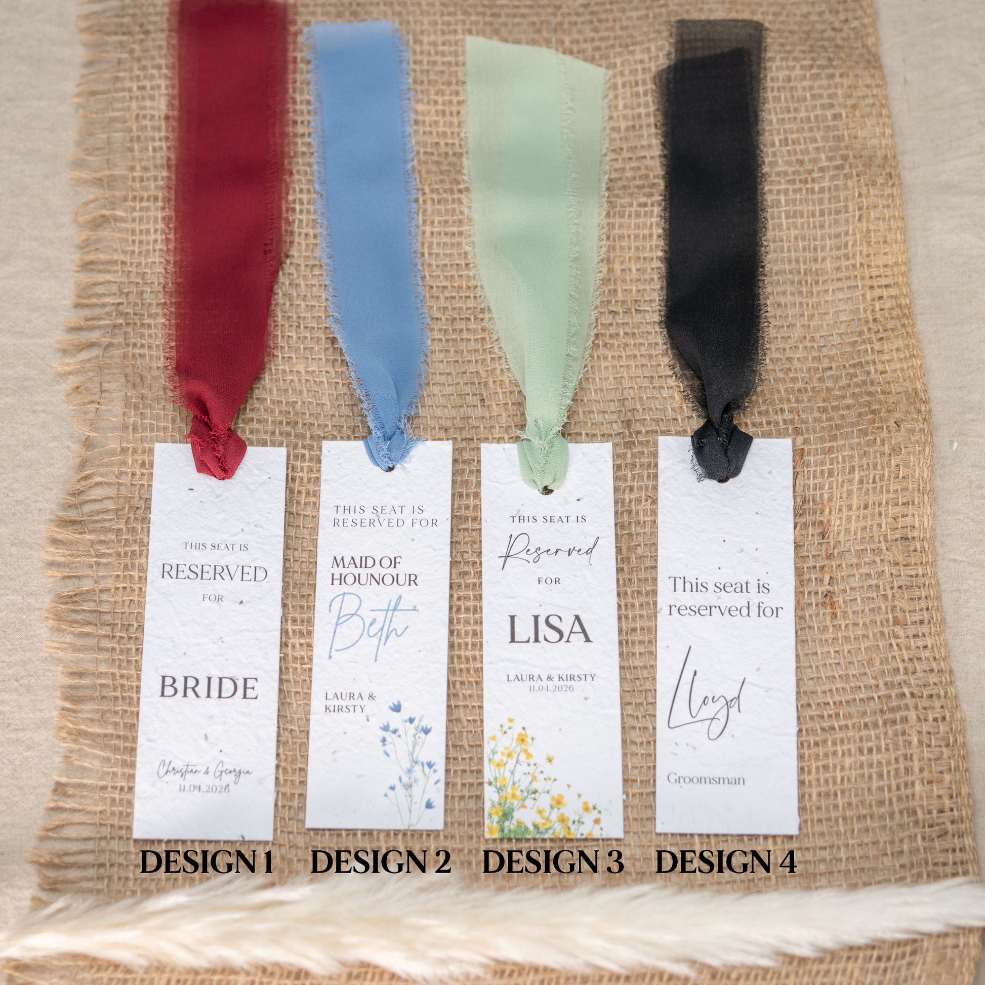 Four wedding seat reservation cards with ribbons on a textured fabric background