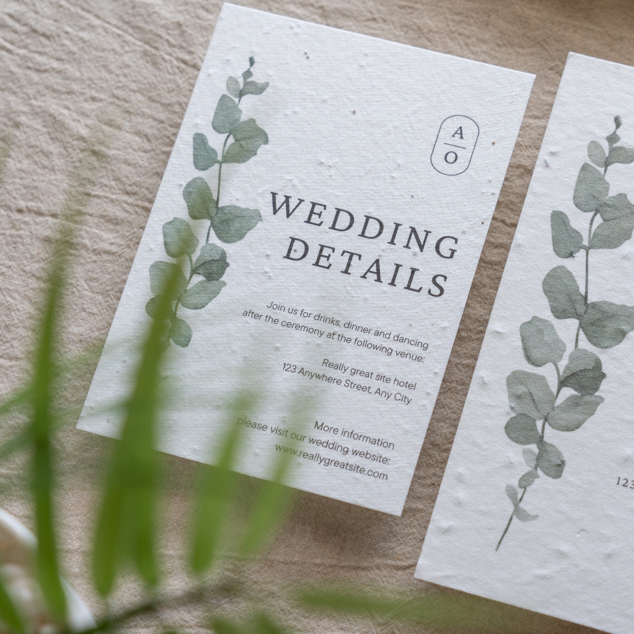 Wedding details card with eucalyptus design on a wooden surface