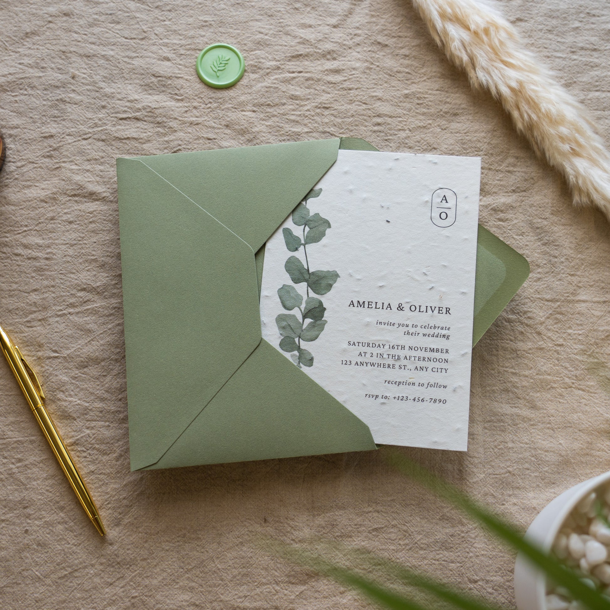 Green envelope with a white card featuring text and leaf design on a textured surface.