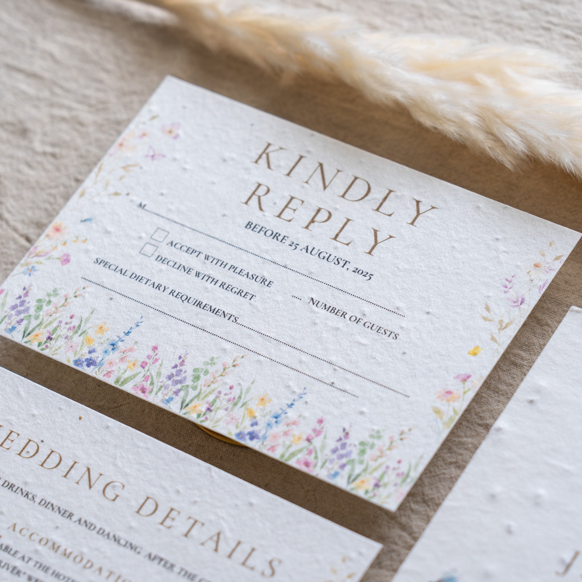 Wedding invitation card with floral design on a wooden surface